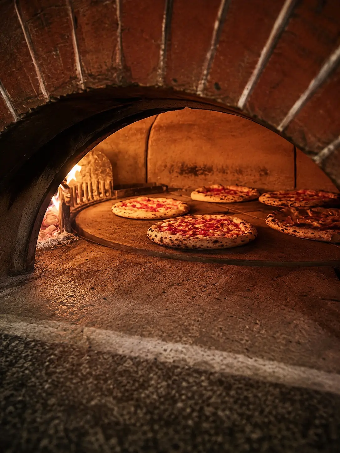 Pizzas napolitaines en cuisson dans le four à bois du Commerce